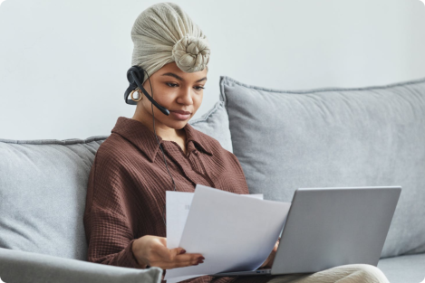women with headset and laptop sitting on the couch